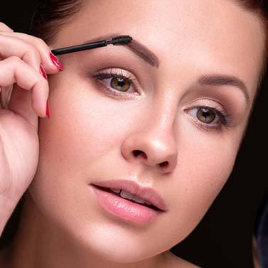 Blondīne, kas lieto uzacu želeju